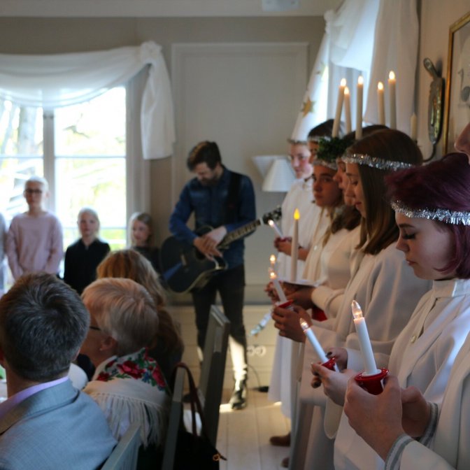 Luciatåget med kören i bakgrunden. Foto: Mattias Fagerholm